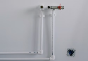 PEX and PVC plumbing pipe penetrations through interior wall sealed with elastomeric non-sag polyurethane sealant
