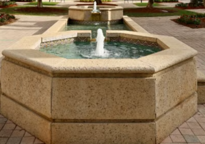 Architectural stone water fountain in commercial courtyard with waterproof coating applied to basin surfaces and tile joints